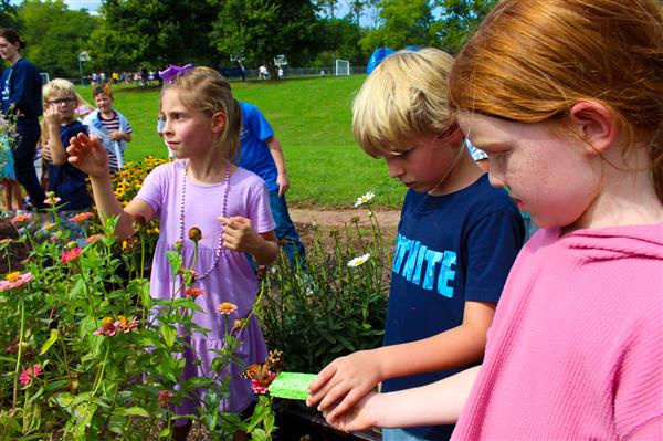 students in a flower garden with butterflies